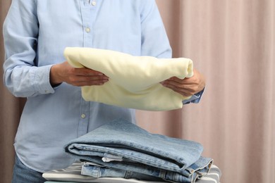 Woman folding clean clothes at home, closeup