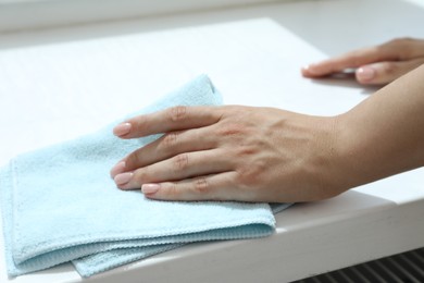 Photo of Woman cleaning windowsill at home, closeup view