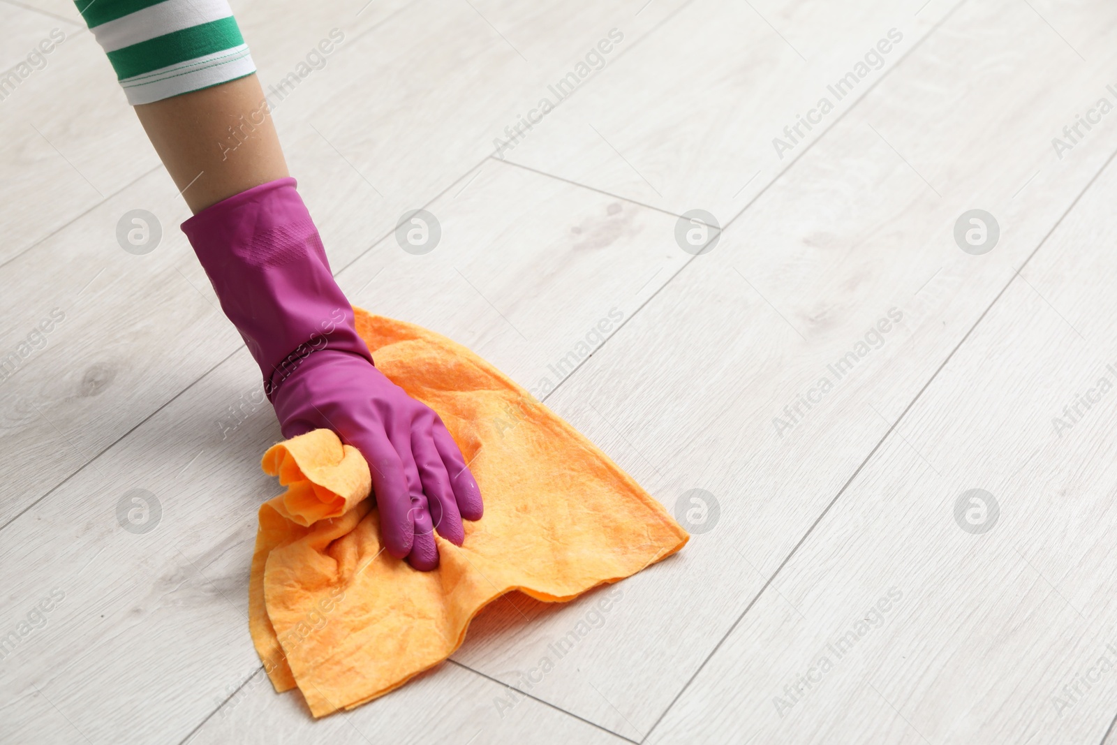 Photo of Woman in glove cleaning floor with rag, closeup. Space for text