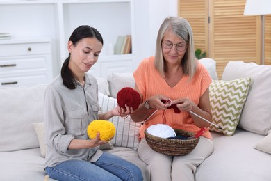 Mother and daughter with skeins of yarn spending time together at home