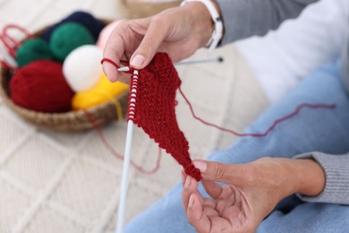 Woman knitting at home, closeup. Handicraft hobby