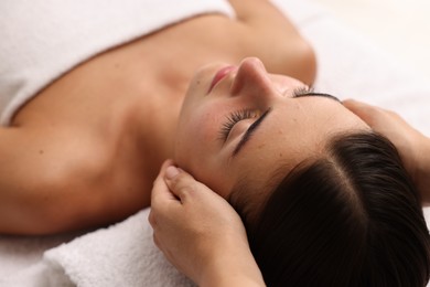 Photo of Attractive woman enjoying face massage, closeup. Beauty procedure