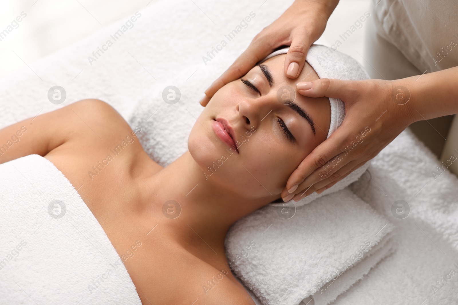 Photo of Attractive woman enjoying face massage, above view. Beauty procedure