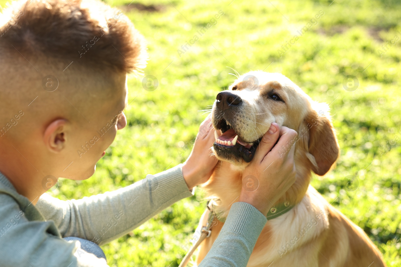 Photo of Young man with his lovely dog in park