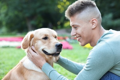 Photo of Young man with his lovely dog in park