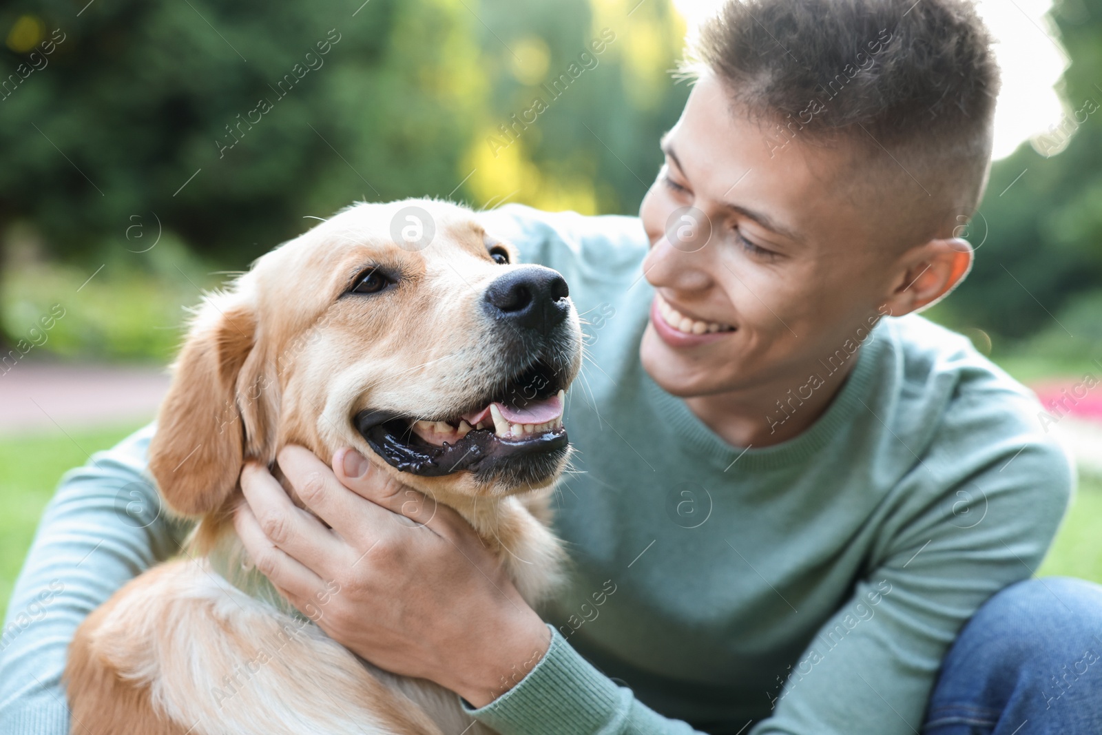 Photo of Young man with his lovely dog in park