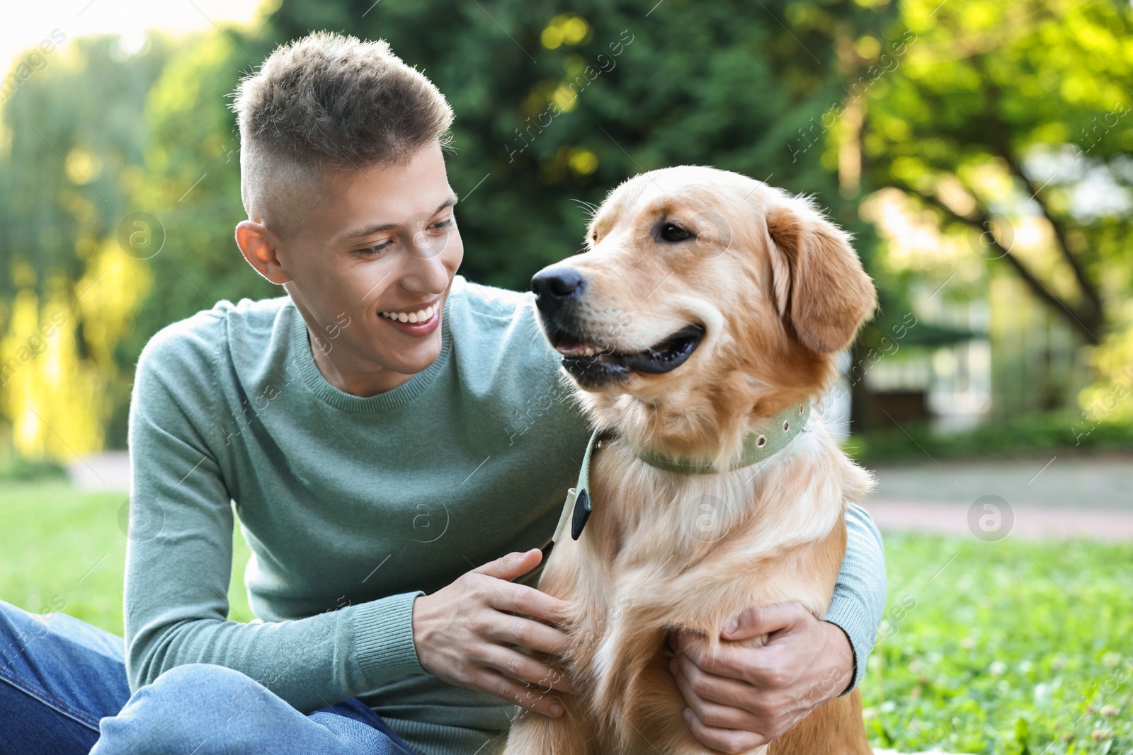 Photo of Young man with his lovely dog in park