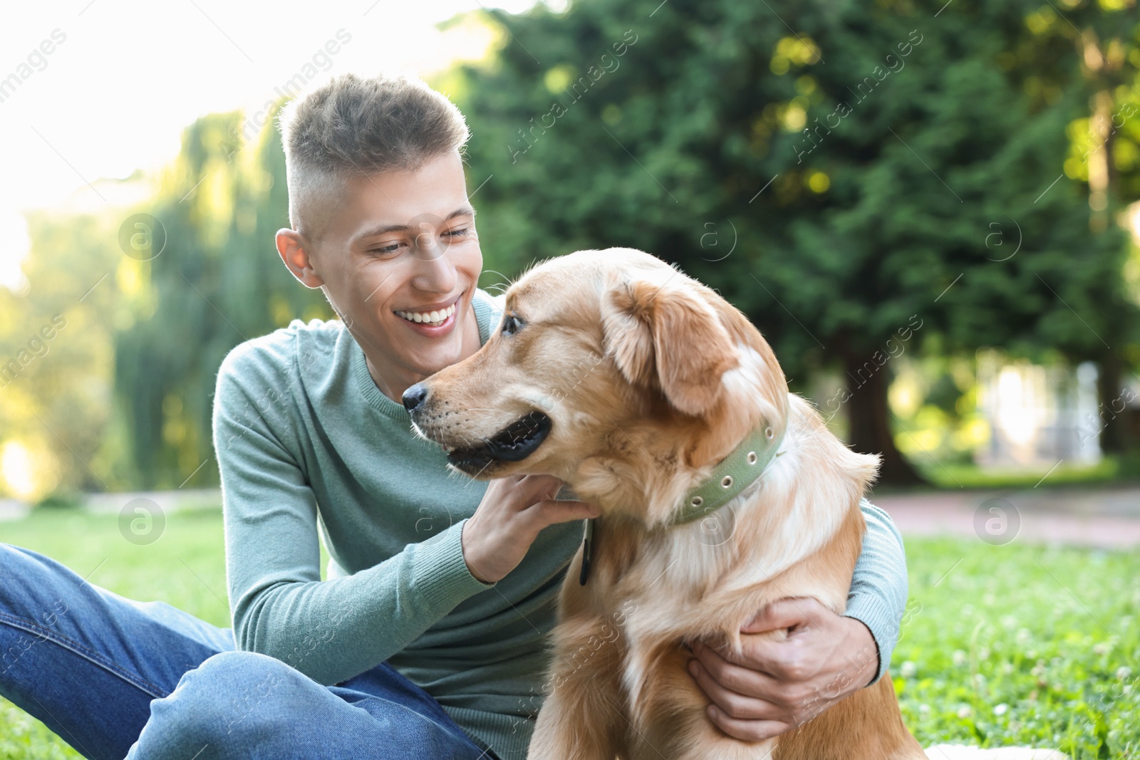 Photo of Young man with his lovely dog in park