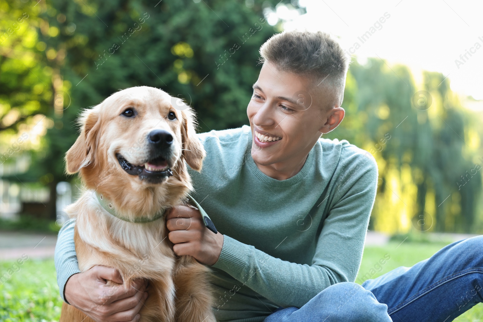 Photo of Young man with his lovely dog in park