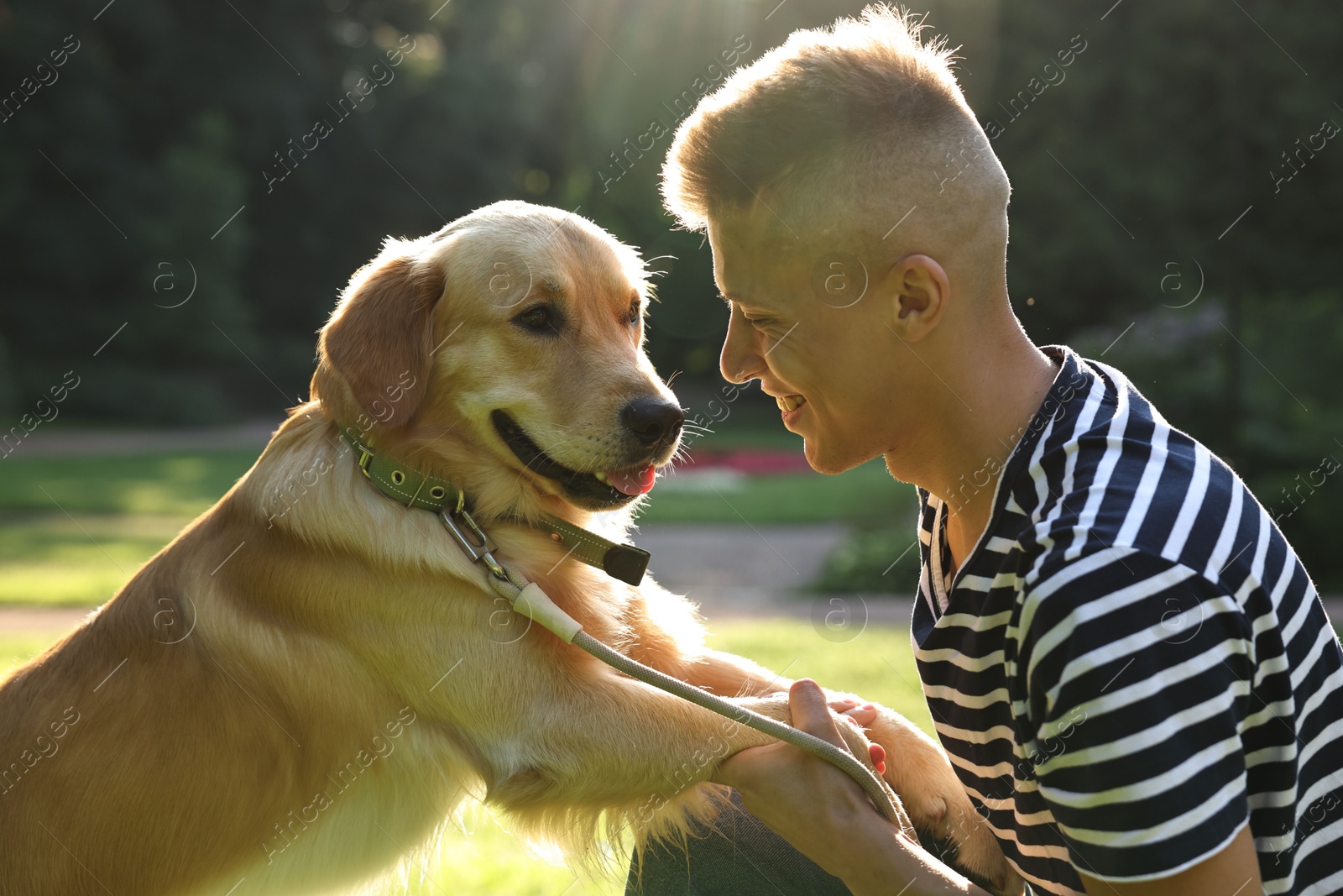 Photo of Young man with his lovely dog in park