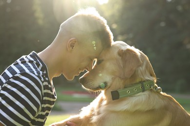 Photo of Young man with his lovely dog in park on sunny day