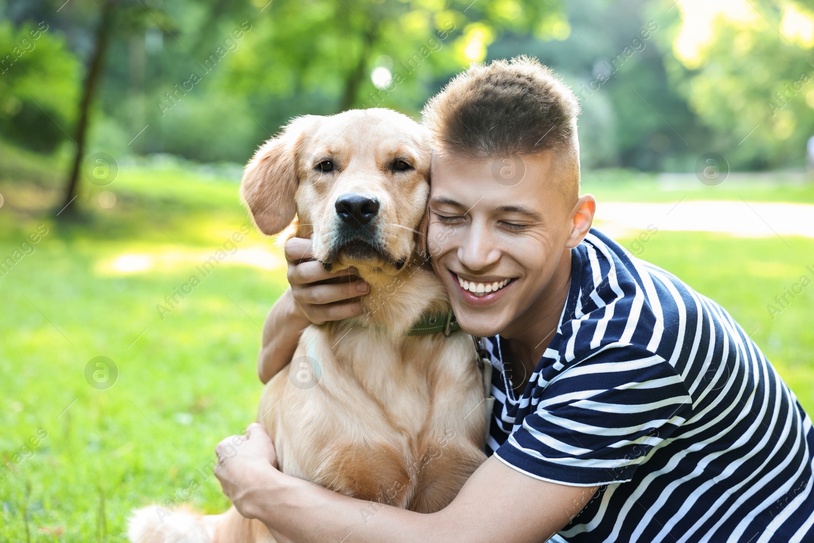 Photo of Young man with his lovely dog in park