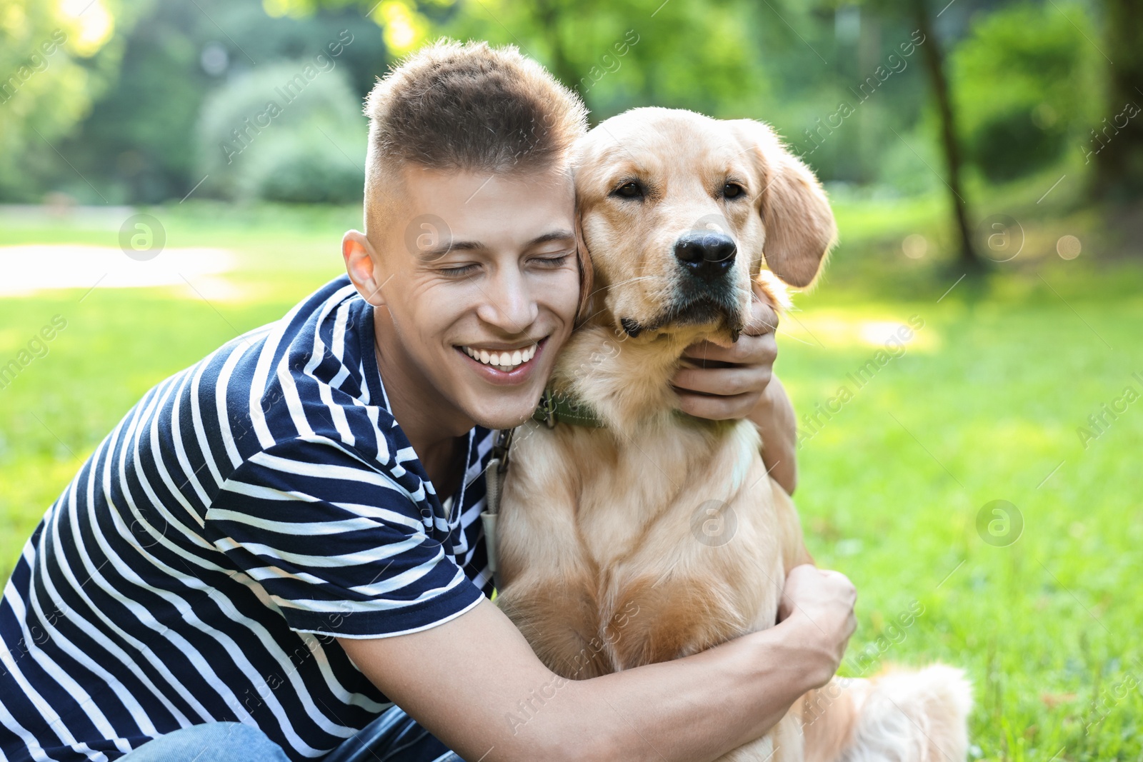 Photo of Young man with his lovely dog in park