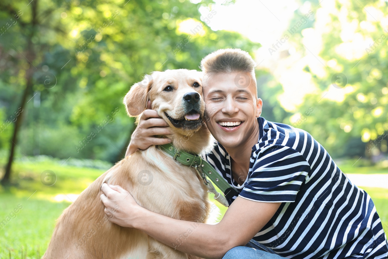 Photo of Young man with his lovely dog in park