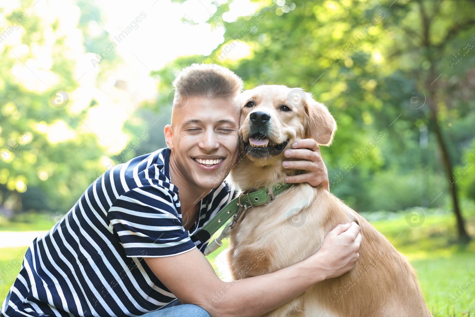 Photo of Young man with his lovely dog in park