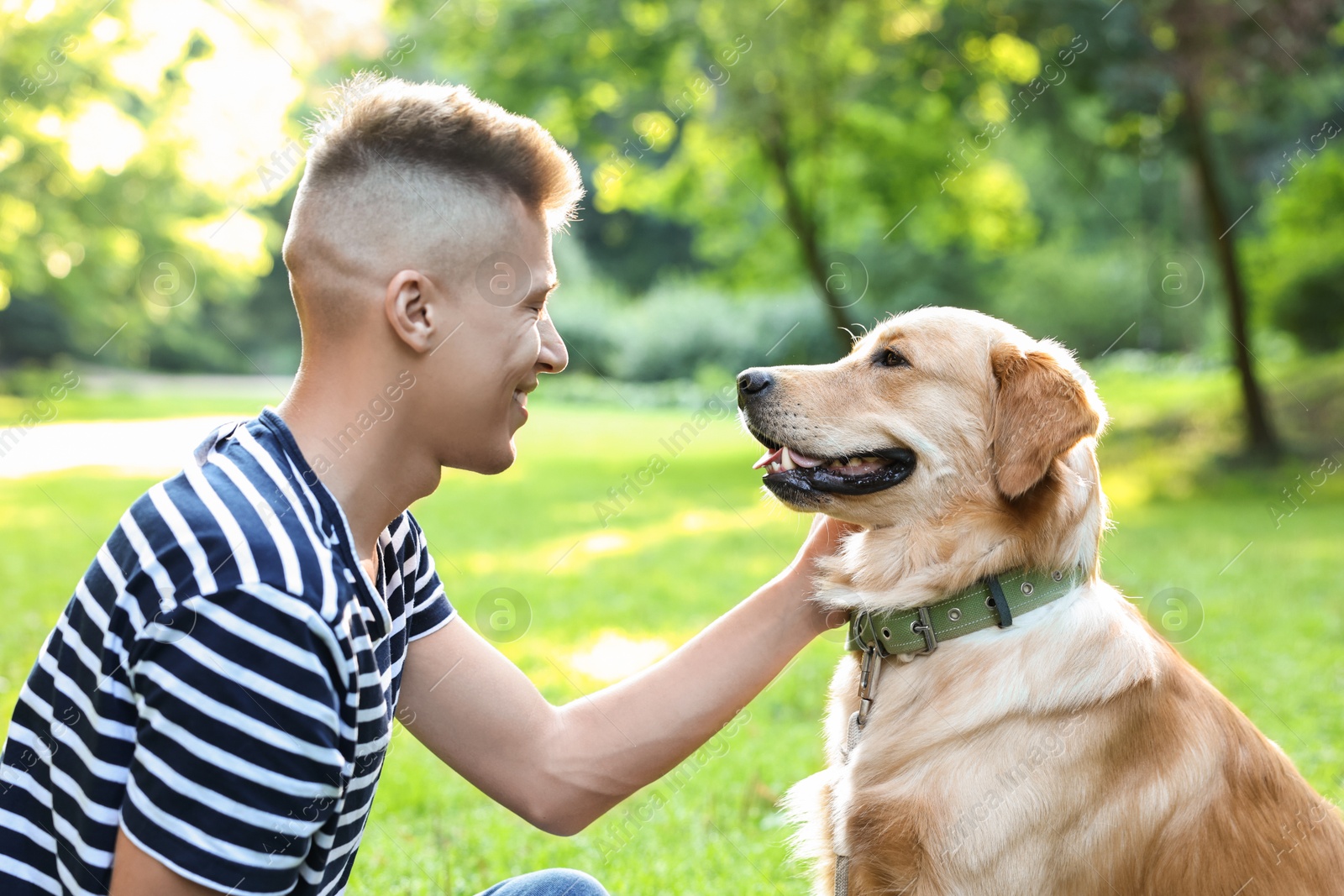 Photo of Young man with his lovely dog in park