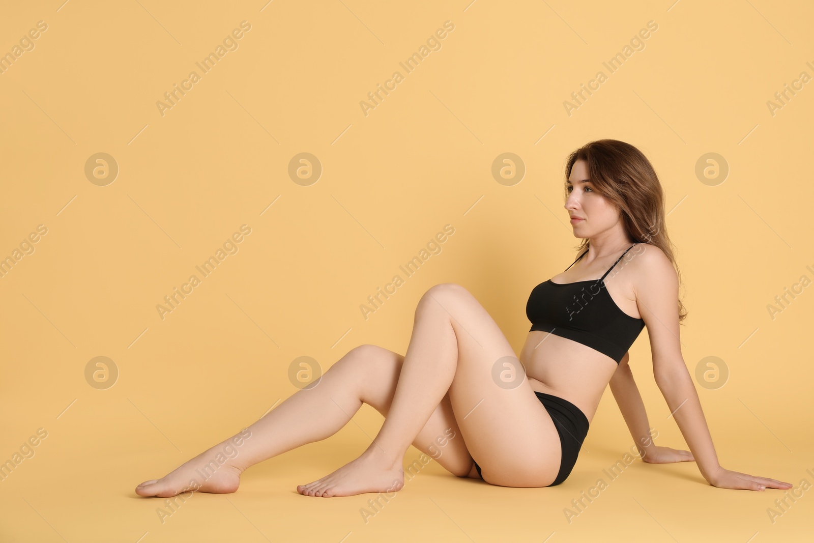 Photo of Woman with slim body posing on yellow background. Space for text