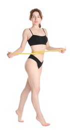 Woman with measuring tape showing her slim body against white background