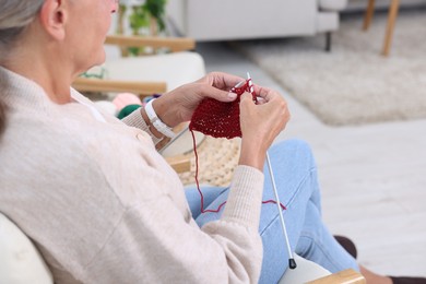 Photo of Woman knitting at home, closeup. Handicraft hobby