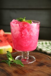 Photo of Tasty watermelon sorbet in glass dessert bowl and mint on table, closeup