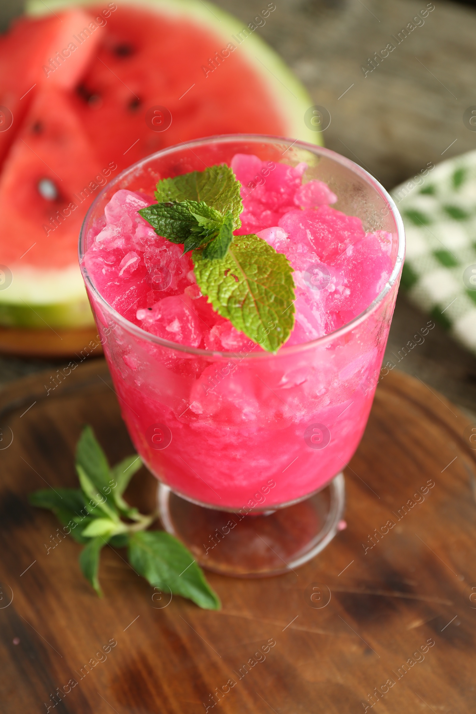 Photo of Tasty watermelon sorbet in glass dessert bowl and mint on table, closeup