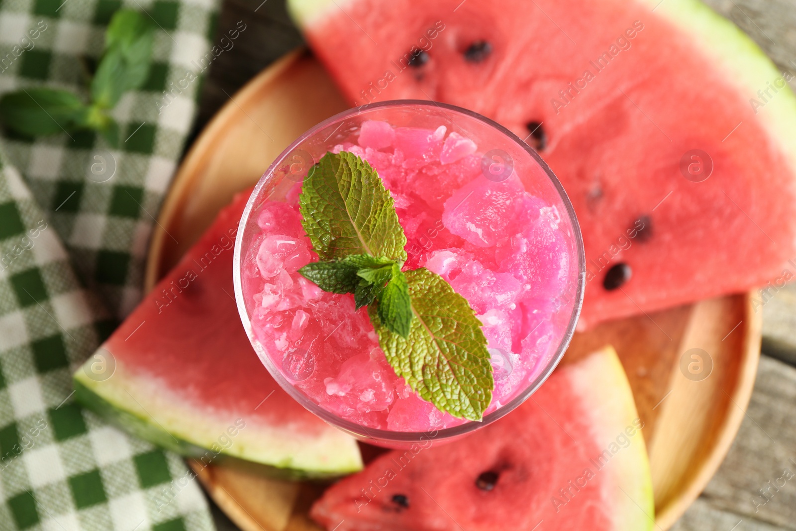 Photo of Tasty watermelon sorbet in glass dessert bowl, fresh fruit and mint on table, top view