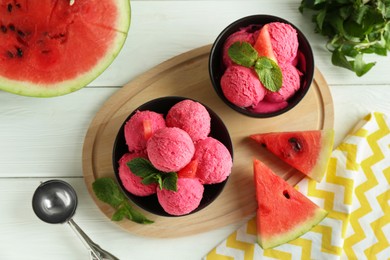 Photo of Scoops of tasty watermelon sorbet in bowls, fresh fruit and mint on white wooden table, top view