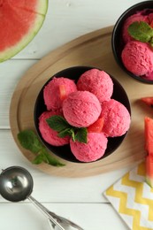 Photo of Scoops of tasty watermelon sorbet in bowls, fresh fruit and mint on white wooden table, top view