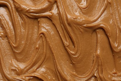 Photo of Tasty peanut butter as background, top view