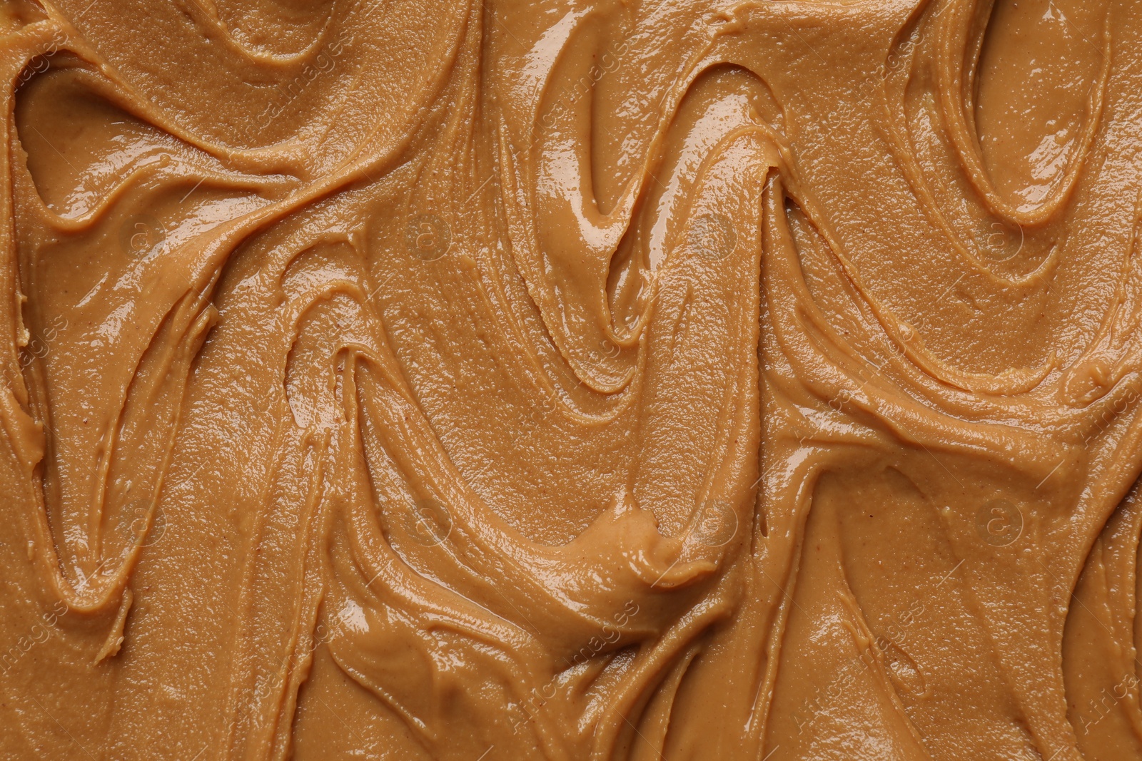 Photo of Tasty peanut butter as background, top view