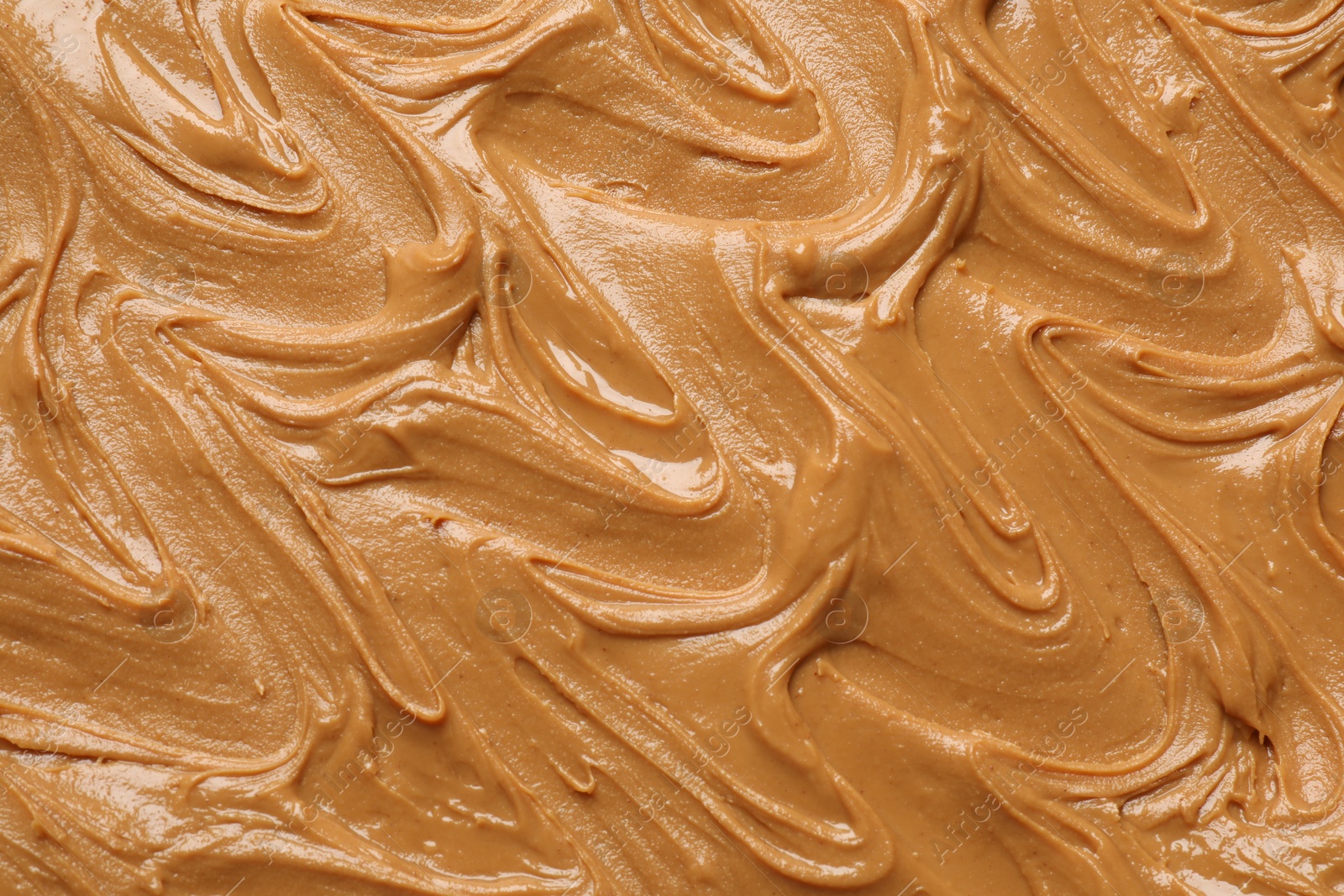 Photo of Tasty peanut butter as background, top view