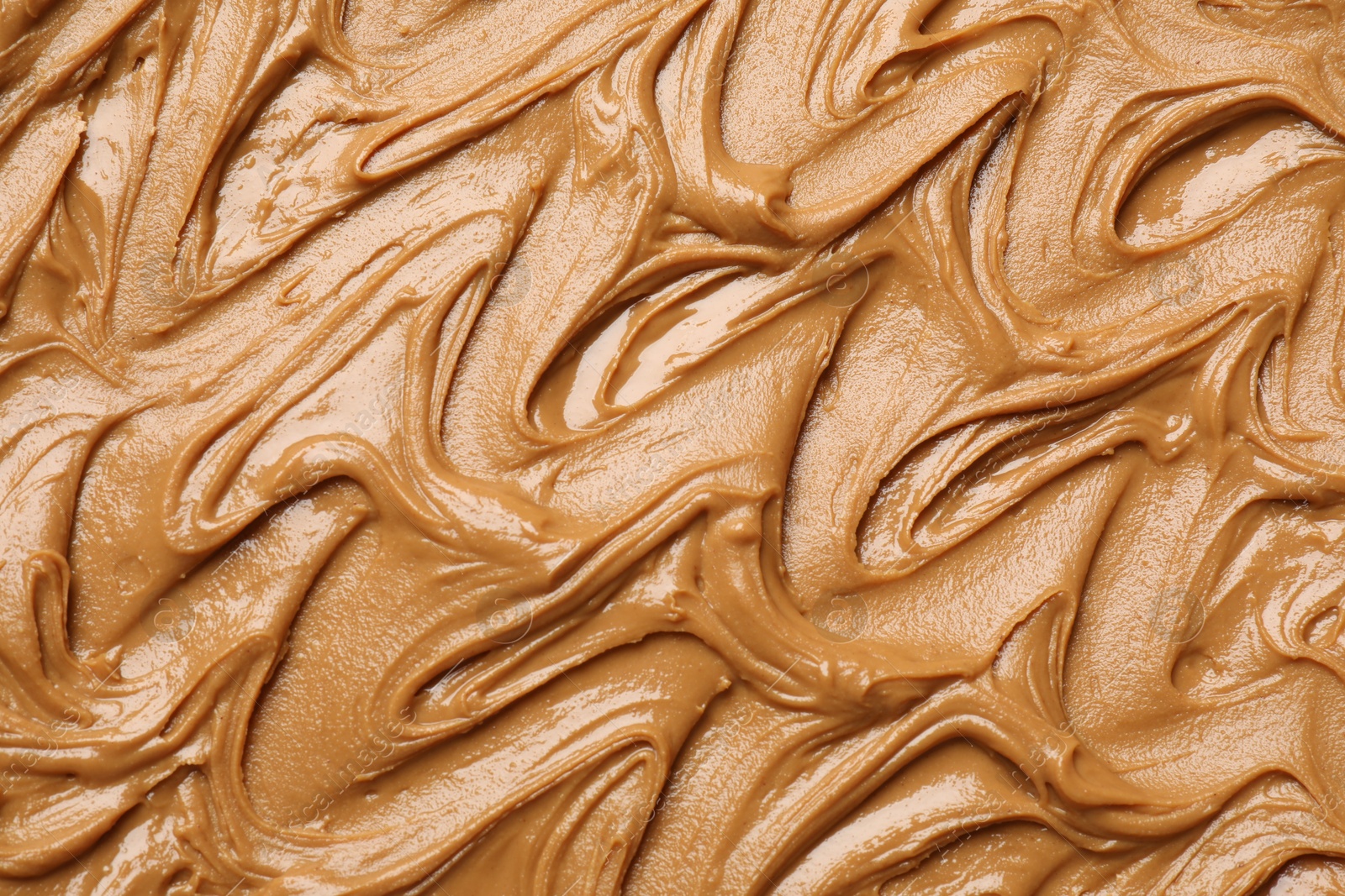 Photo of Tasty peanut butter as background, top view