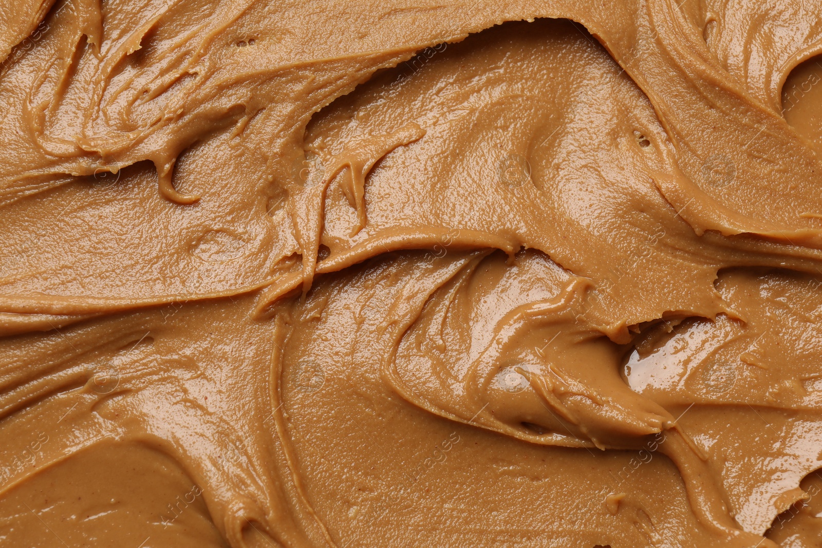 Photo of Tasty peanut butter as background, top view