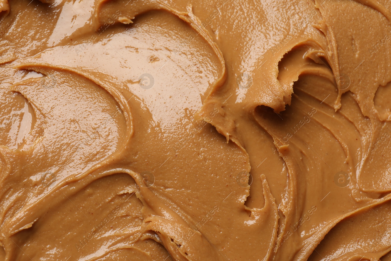 Photo of Tasty peanut butter as background, top view