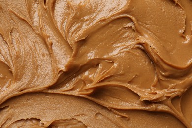 Photo of Tasty peanut butter as background, top view