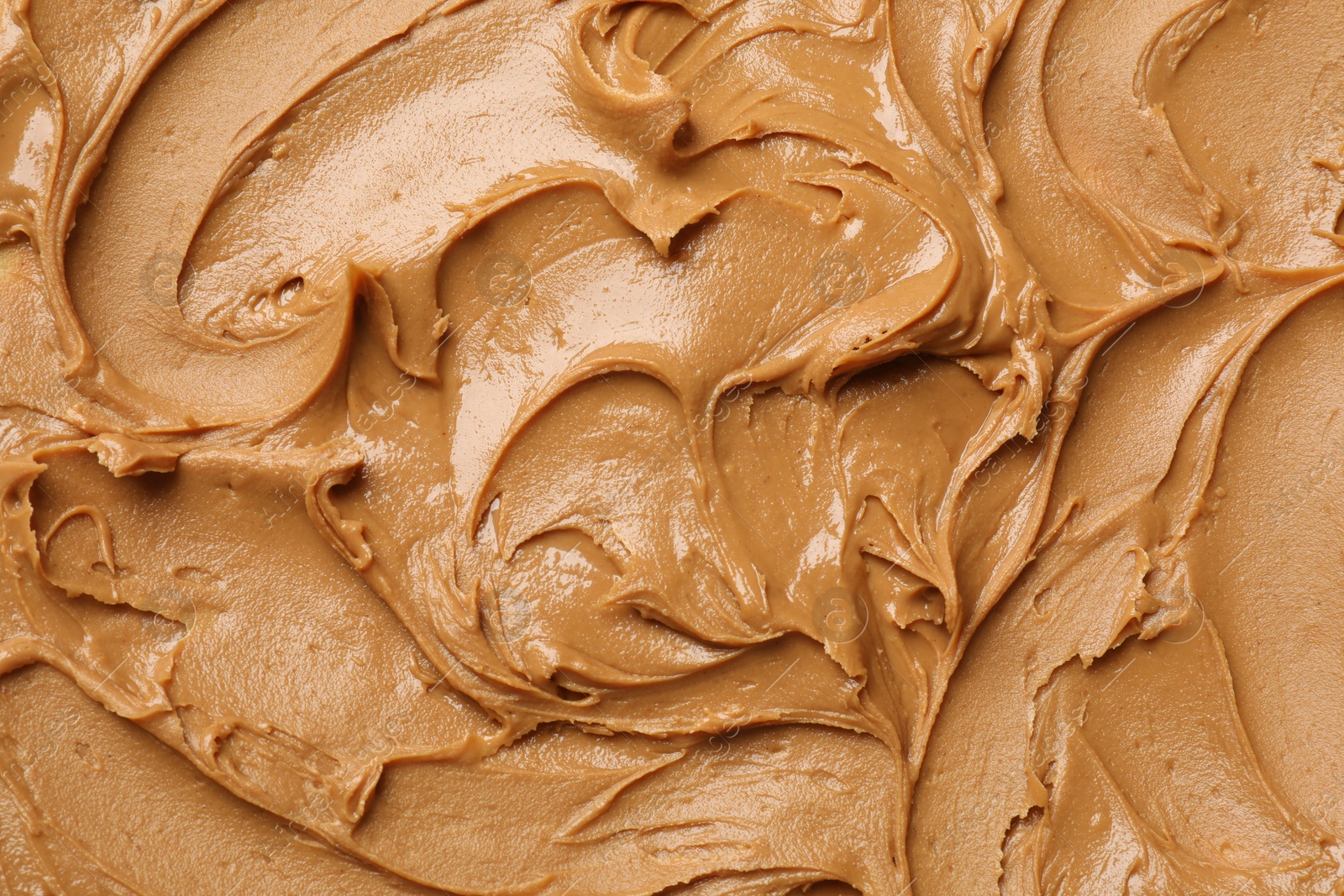 Photo of Tasty peanut butter as background, top view