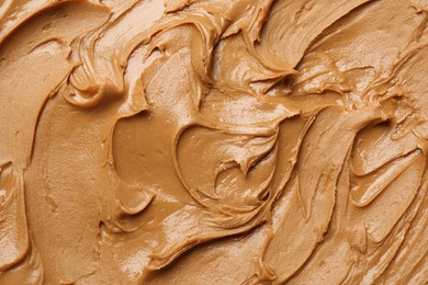 Photo of Tasty peanut butter as background, top view