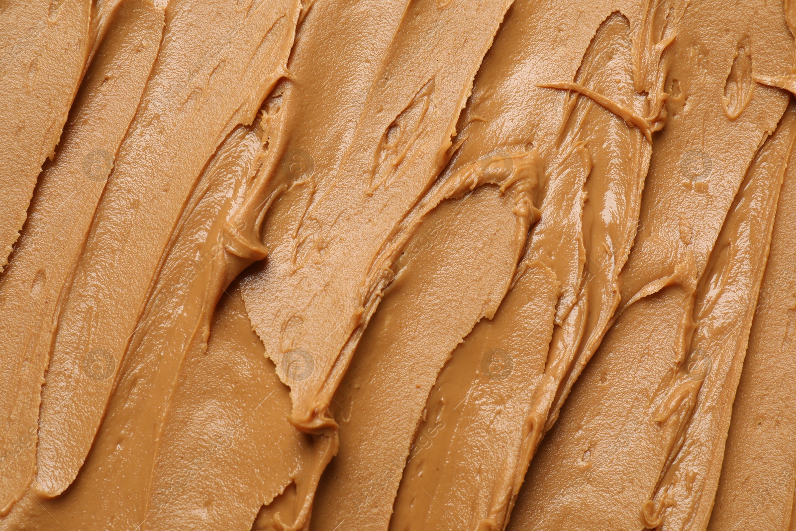 Photo of Tasty peanut butter as background, top view