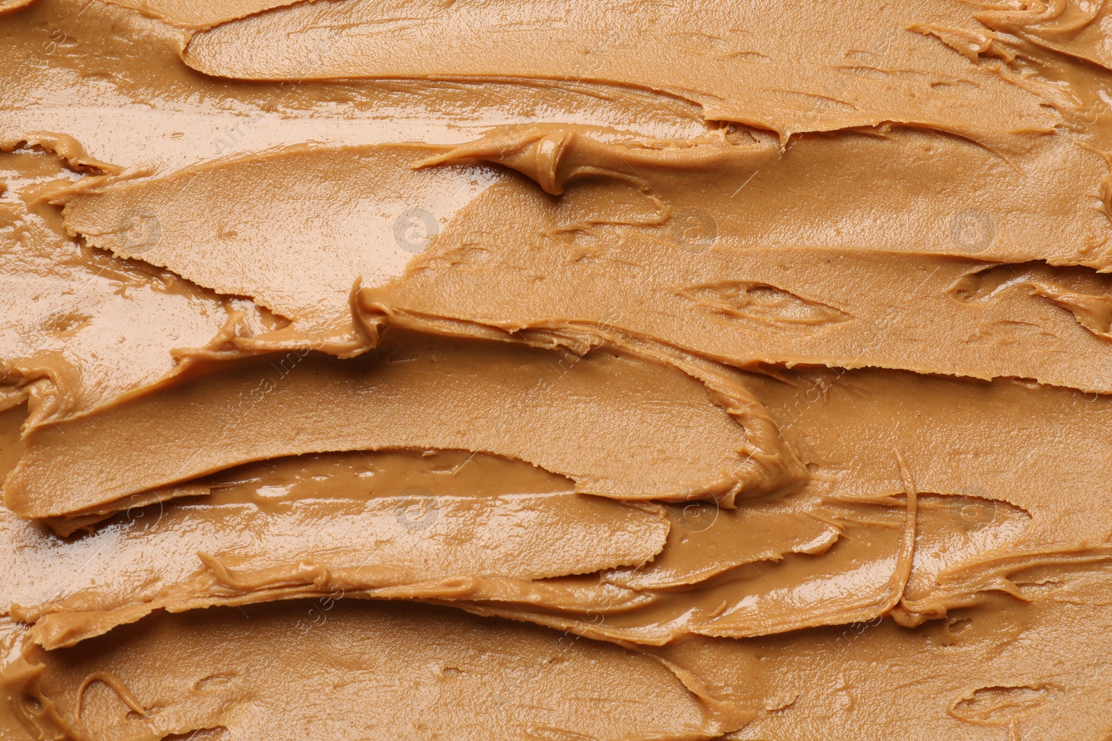 Photo of Tasty peanut butter as background, top view