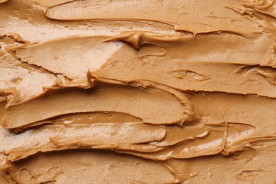 Photo of Tasty peanut butter as background, top view