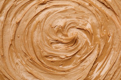 Photo of Tasty peanut butter as background, top view