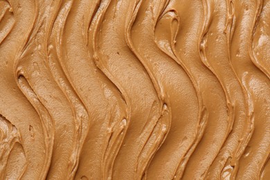 Photo of Tasty peanut butter as background, top view