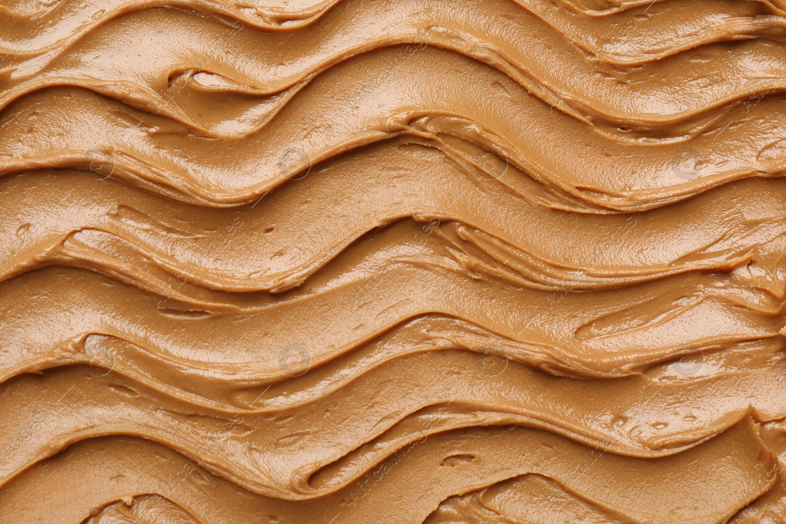 Photo of Tasty peanut butter as background, top view