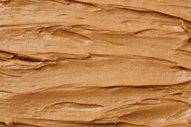 Photo of Tasty peanut butter as background, top view