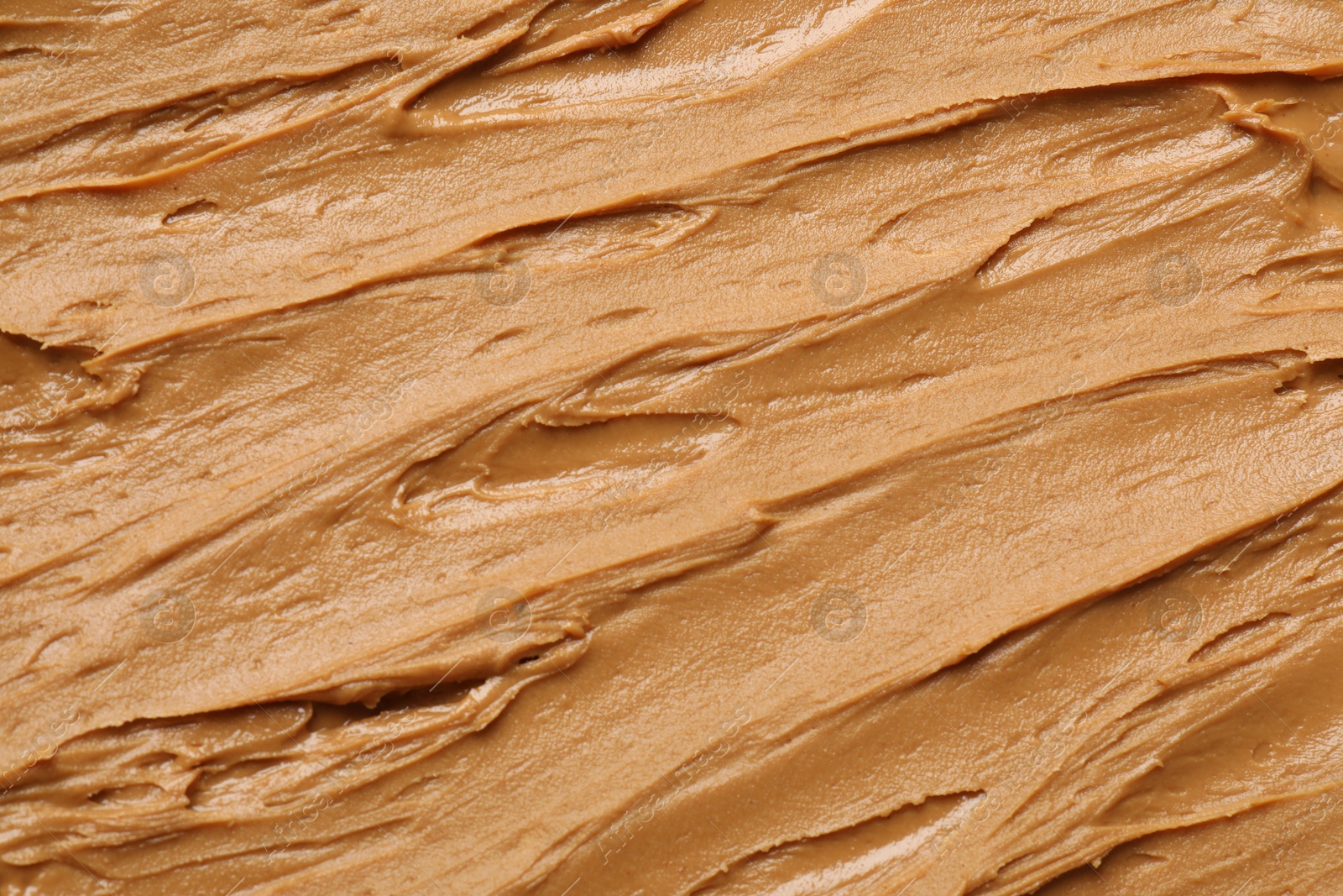 Photo of Tasty peanut butter as background, top view