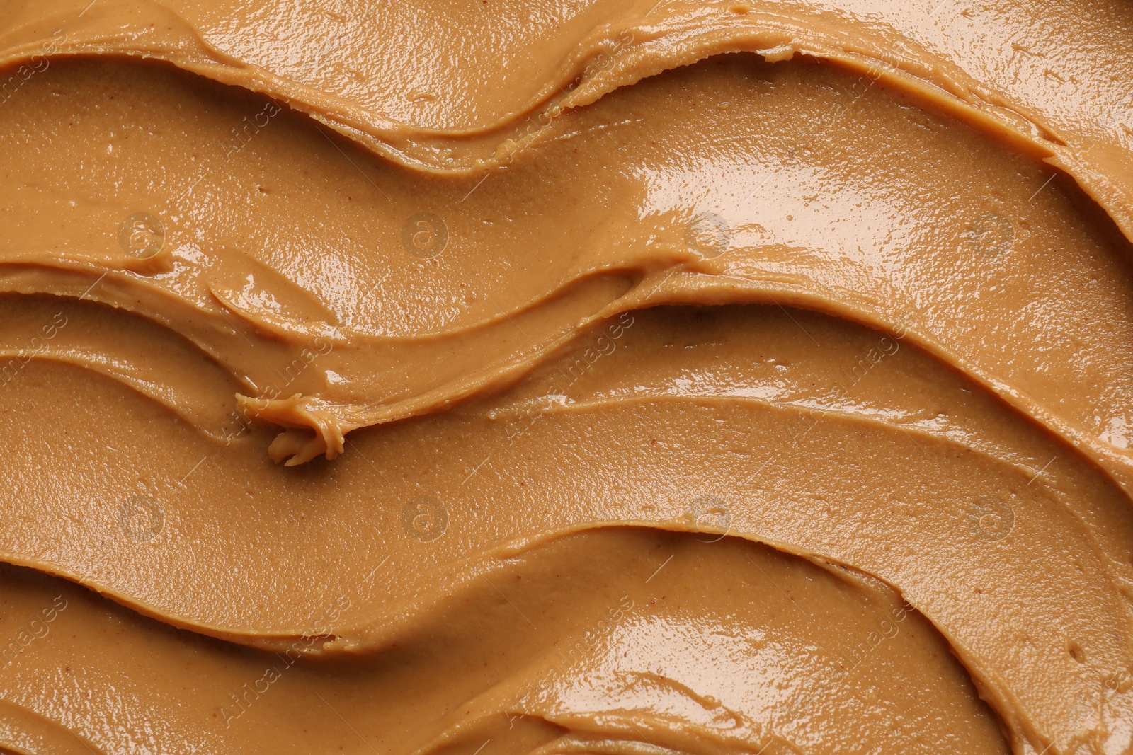 Photo of Tasty peanut butter as background, top view