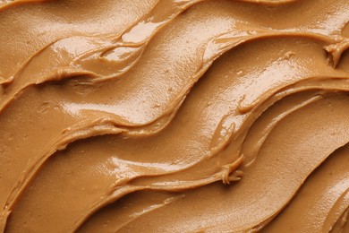 Photo of Tasty peanut butter as background, top view