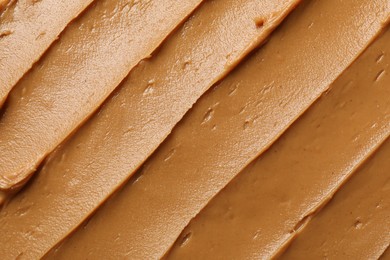 Photo of Tasty peanut butter as background, top view