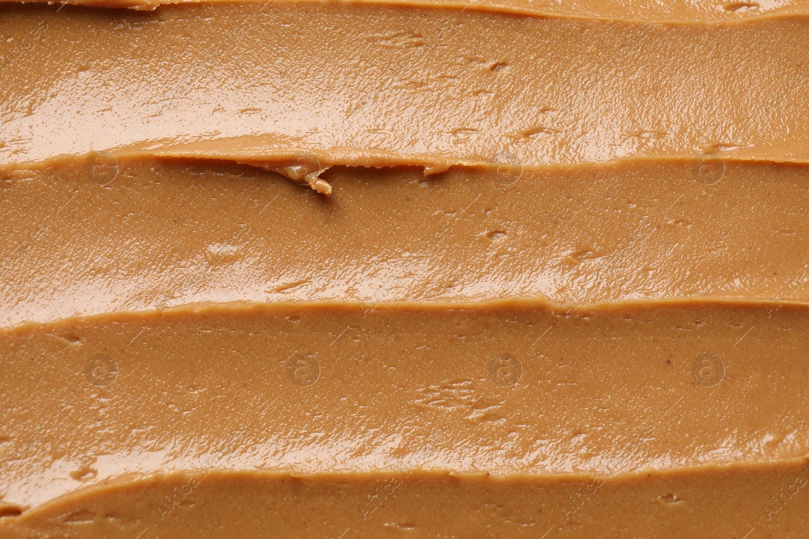 Photo of Tasty peanut butter as background, top view