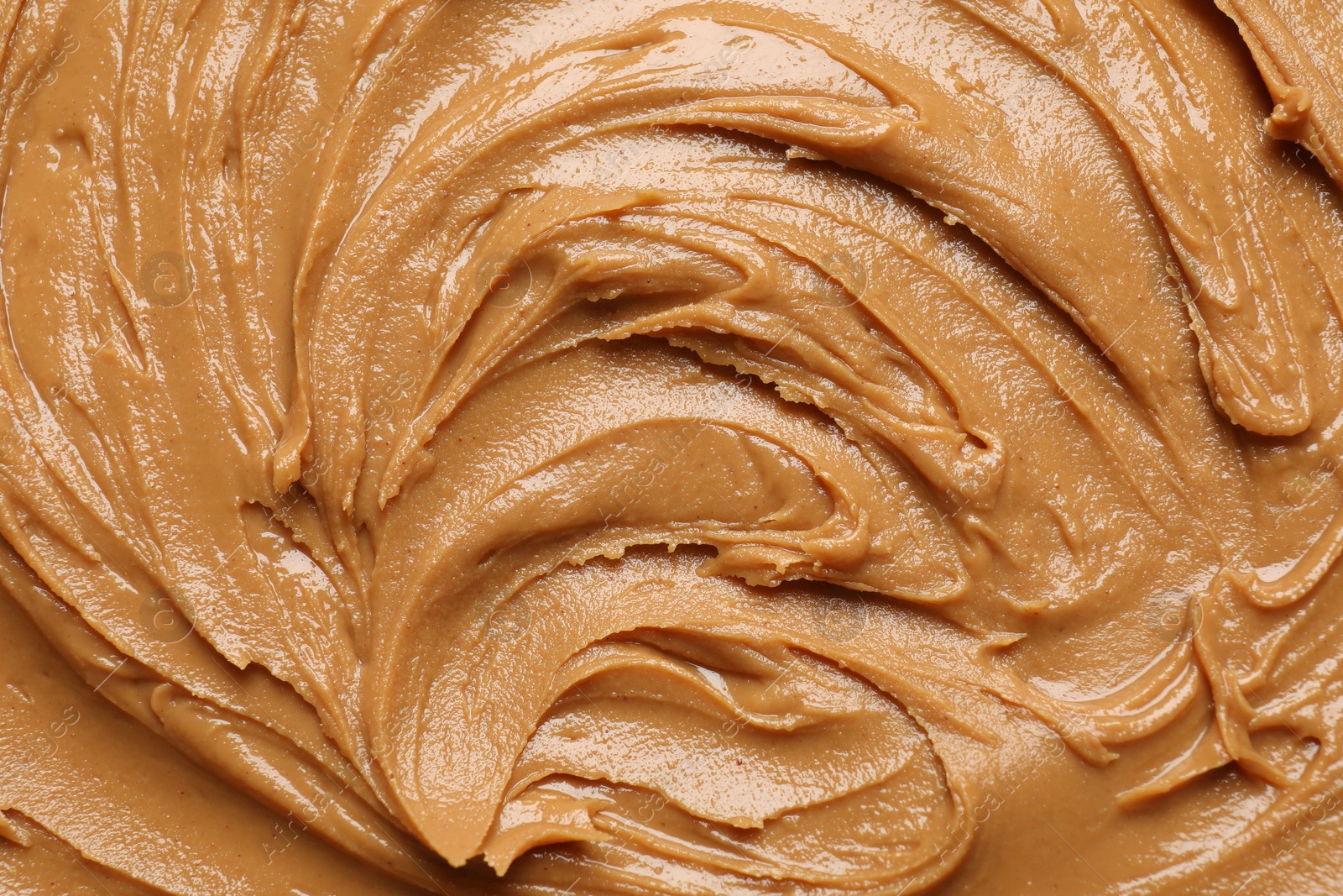 Photo of Tasty peanut butter as background, top view